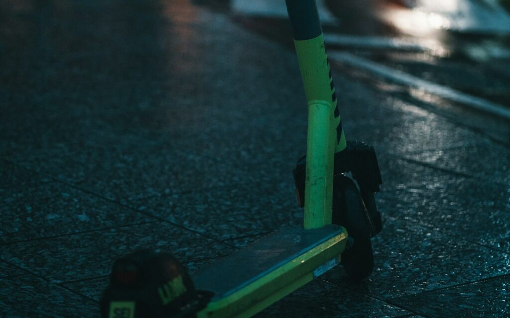 Trottinette électrique en hiver, garée sur un trottoir mouillé la nuit